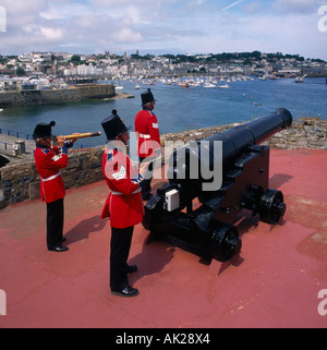 Trois soldats en uniforme militaire rouge le feu d'artillerie Noon Day Gun salute à Castel Cornet à St Peter Port Guernsey Banque D'Images