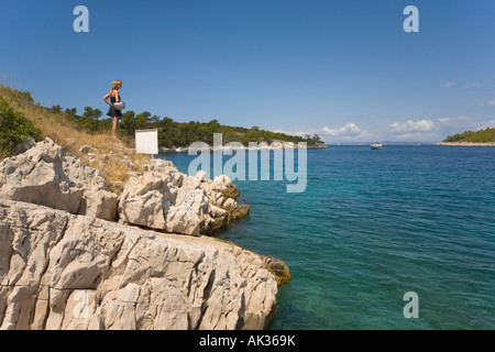 Motocycliste italien en minijupe avec casque donne sur Bay à l'île de Hvar Croatie Camp Vira Banque D'Images