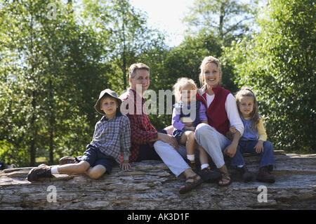 Portrait d'une famille de cinq assis sur un journal Banque D'Images