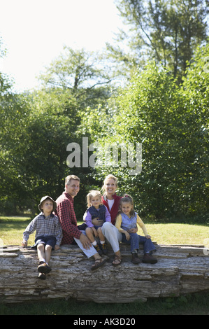 Portrait d'une famille de cinq assis sur un journal Banque D'Images