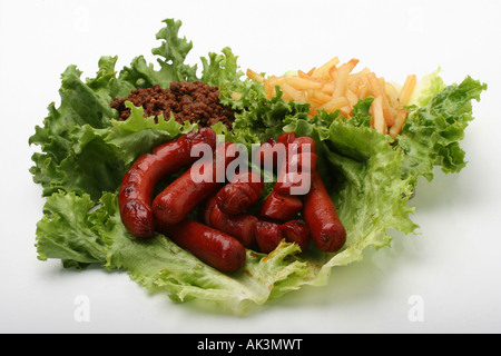 Saucisses rôties avec frites de bœuf viande de piment salade verte restauration rapide personne vue de dessus sur fond blanc découpe isolée haute résolution Banque D'Images