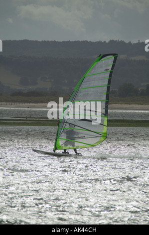 Planche à voile dans l'estuaire de la rivière Exe Dawlish Dawlish Warren avec en arrière-plan Grande-bretagne Devon Banque D'Images