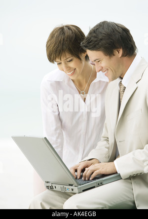 Businessman and woman using laptop Banque D'Images