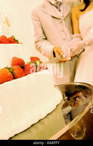Couple de couper le gâteau de mariage, close-up Banque D'Images