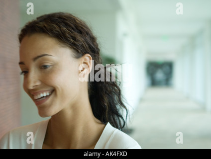 Femme debout dans le couloir, riant, portrait Banque D'Images