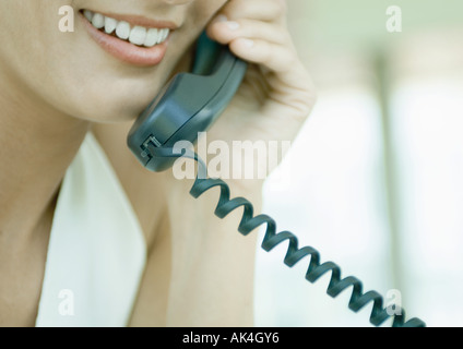 Femme à l'aide de téléphone fixe Banque D'Images