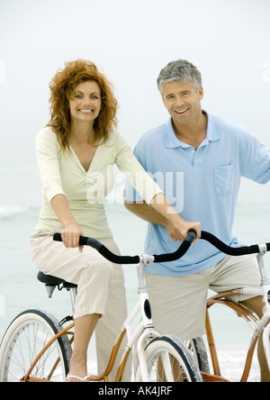 Couple riding bikes on beach Banque D'Images