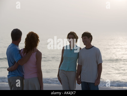 Deux couples d'âge mûr sur la plage au crépuscule Banque D'Images