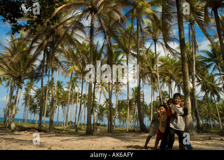 Les enfants qui jouent ensemble sous des centaines de cocotiers à Terengganu Malaisie Banque D'Images