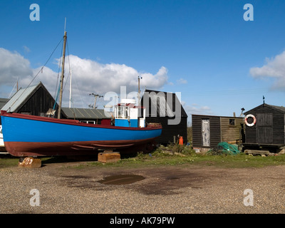 Cabanes de pêcheurs en bois bleu et un bateau de pêche au port de Southwold, Suffolk, Angleterre, Royaume-Uni Banque D'Images