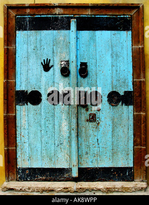 Vieille porte en bois peint en bleu clair avec des décorations en métal noir Banque D'Images