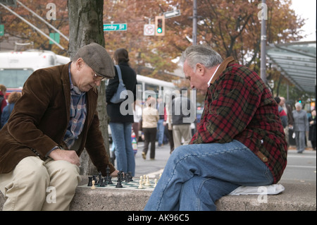 Deux hommes plus âgés jouant aux échecs en plein air au Robson Square, Vancouver BC Banque D'Images