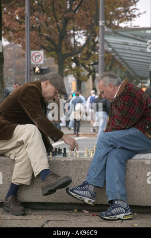 Deux hommes plus âgés jouant aux échecs en plein air au Robson Square, Vancouver BC Banque D'Images