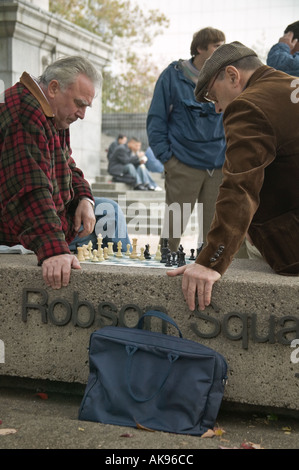 Deux hommes plus âgés jouant aux échecs en plein air au Robson Square, Vancouver BC Banque D'Images