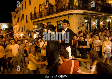 Un homme de la manipulation d'un cheval nerveux à la rue fiesta à Mahon, Minorque Banque D'Images