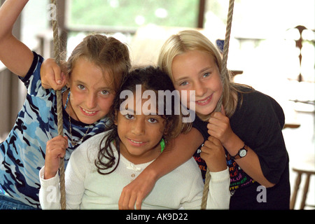 Les amies de 11 ans jouant sur porche swing pendant les vacances d'été. Cedarville Michigan USA Banque D'Images