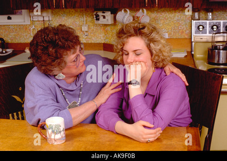 Mère fille réconfortante l'âge de 17 & 50 à table de cuisine. St Paul Minnesota USA Banque D'Images