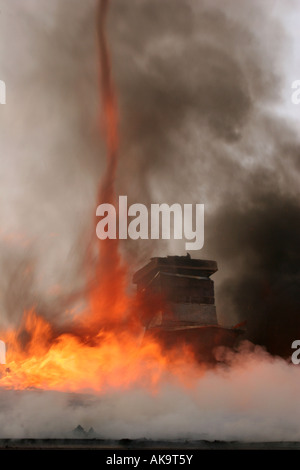 Flammes formant un Tornado de la chaleur et de la fumée du toit d'une maison en feu Banque D'Images