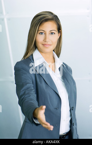 Young businesswoman smiling and holding out hand de camera, portrait Banque D'Images