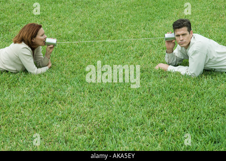 Couple d'orientation sur le terrain, parler à l'autre par tin can phone Banque D'Images