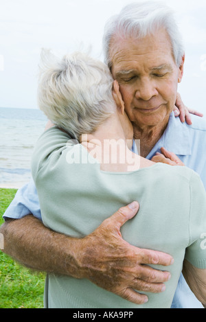 Senior couple hugging man, fermer les yeux, close-up Banque D'Images