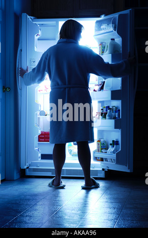 Ouverture d'un réfrigérateur femme midnight snack Banque D'Images