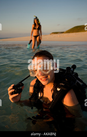 Deux jeunes filles profitez de l'attrait de l'océan en entrant dans les eaux à Gibb's Cay, Îles Turks et Caicos. Banque D'Images