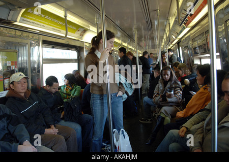 Une voiture multi-ethnic de métro traverse le pont de Manhattan sur le D train à NYC pendant leur trajet du matin Banque D'Images