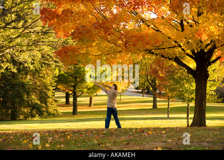 Garçon jouant dans le parc avec les couleurs d'automne. jouant avec sa fronde Banque D'Images