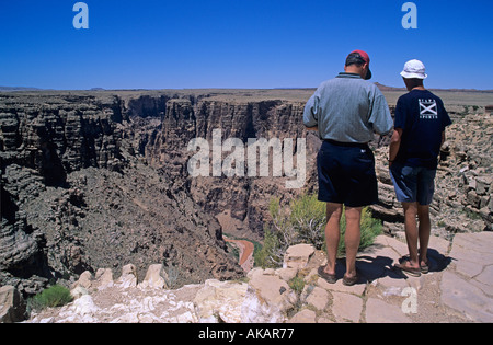 Deux personnes debout sur le bord d'une gorge dans le cadre d'une série de canyons près du Grand Canyon avec le fleuve Colorado ci-dessous Banque D'Images