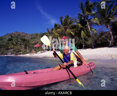 Couple de traction d'une pirogue au large une plage tropicale sur la grande chaume Caraïbes Îles Vierges Britanniques Banque D'Images