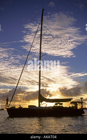 Silhouetté contre yacht coucher de soleil avec personne à bow Banque D'Images