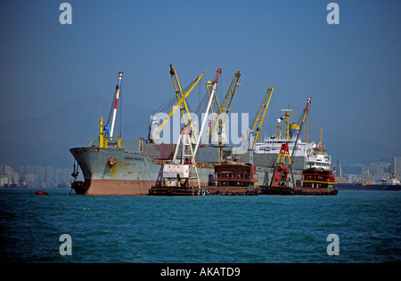 Les navires de chargement des marchandises dans le port de Hong Kong à l'aide de navires de transfert Banque D'Images