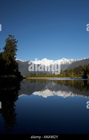 Sommets du Mt Tasman à gauche et droite de Aoraki Mt Cook reflète dans Lake Matheson Westland National Park Côte ouest de l'île du Sud NZ Banque D'Images
