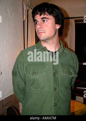 Jeune homme aux cheveux noirs portant une chemise verte Banque D'Images