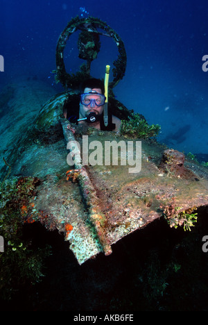 Un mâle scuba diver est assis à l'intérieur de l'épave de l'avion Bombardier Betty Truk en Micronésie Banque D'Images