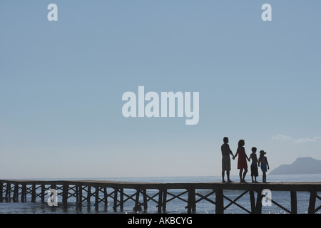 Silhouettes de parents et d'enfants (6-11) on jetty Banque D'Images