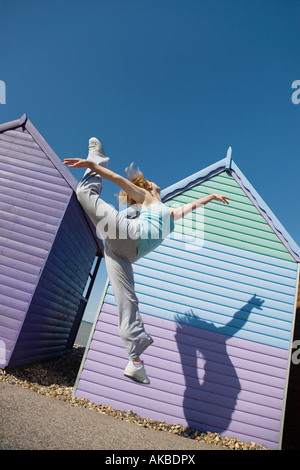 Femme de sauter devant beach hut Banque D'Images