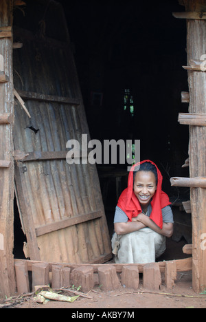 Un producteur de café éthiopien attend à la porte de sa maison avant qu'elle va choisir, Utacha, Yirgacheffe, Ethiopie Banque D'Images