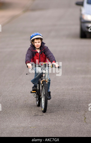 Garçon de huit ans équitation vélo sur route Banque D'Images