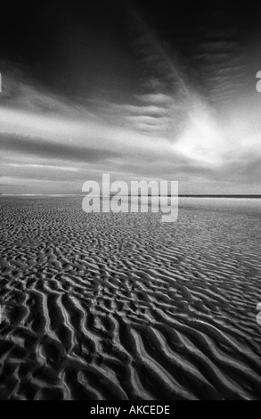 North Norfolk paysage noir et blanc du ciel et de la plage, au crépuscule, en montrant des ondes fait dans le sable à partir de la marée descendante. Banque D'Images