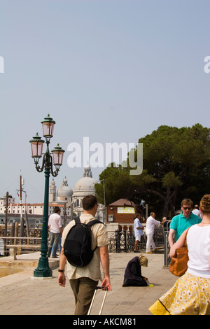 Femme mendiant sur Molo San Marco avec l'église Santa Maria della Salute dans la distance Venise Italie Banque D'Images