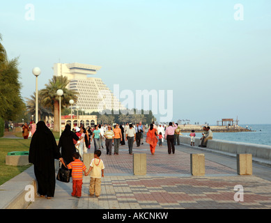 Les familles bénéficiant d'une sortie sur la Corniche à Doha au Qatar avec l'historique de l'hôtel Sheraton de Doha, au loin. Banque D'Images