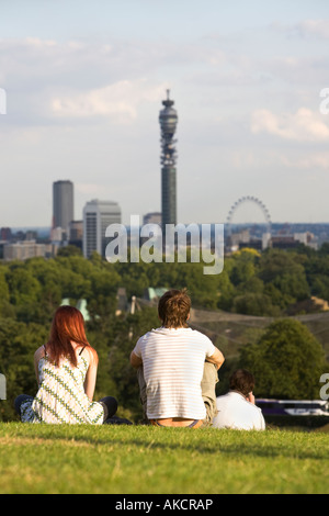 Un jeune couple assis sur Primrose Hill profitant de la vue sur les toits de Londres. Regent's Park, Londres, Angleterre. Banque D'Images