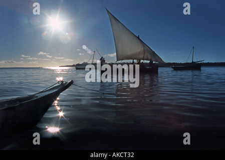 Les gens de convoyage d'un boutre passager Chole Island à l'île de Mafia voisins silhouetté contre le soleil levant Mafia Tanzanie Banque D'Images