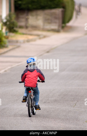 Garçon de huit ans équitation vélo sur route Banque D'Images
