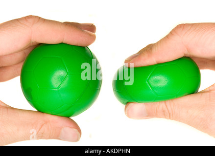 Une photographie de la main d'un homme serrant une balle anti stress vert. Banque D'Images