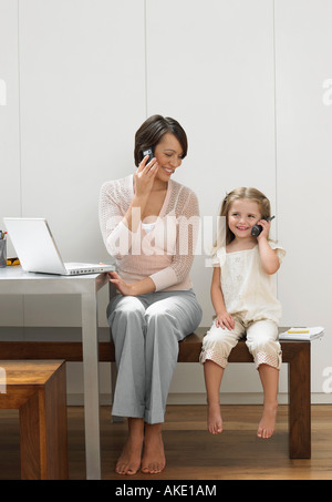 Mère et fille à l'aide de téléphones mobiles Banque D'Images