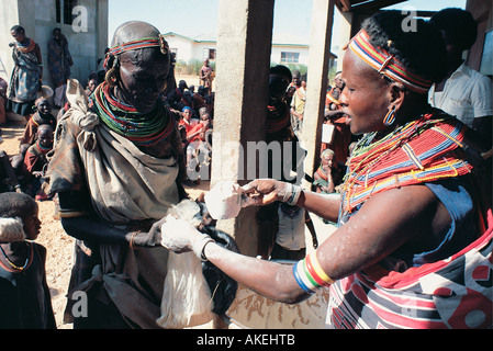 Une femme Samburu la distribution de maïs ou la farine de maïs à Laisamis Mission catholique dans le nord du Kenya Afrique de l'Est Banque D'Images