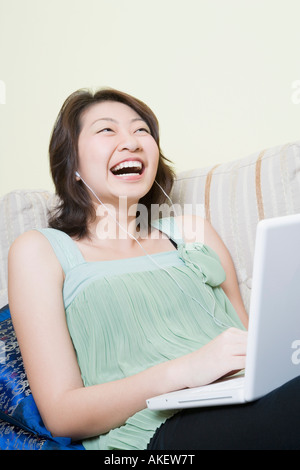 Jeune femme utilisant un ordinateur portable et de rire